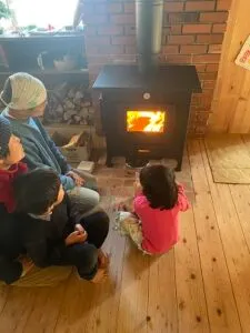 薪ストーブの火を眺めるご家族